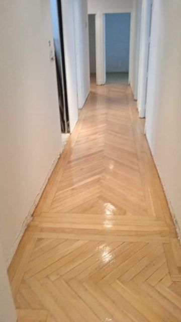 Pasillo largo de parquet en espiga barnizado